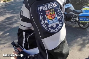 policyjny motocyklista stoi przy drodze