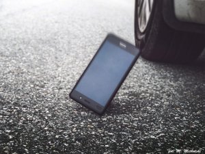 Smartfon spadający na drogę