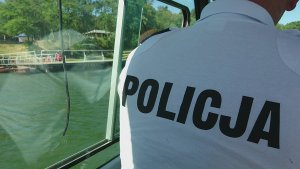 Policjant płynący łódką patroluje brzegi jeziora.
