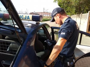 Policjant sprawdzający trzeźwość pijanego kierowcy w radiowozie