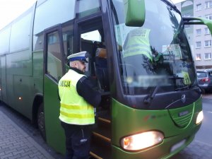 Na zdjęciu dwóch funkcjonariuszy Inspekcji Transportu Drogowego dokonujących kontroli autobusu.