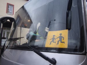 znak uwaga dzieci za szybą w autobusie
