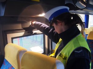 policjantka kontrolująca wnętrze autobusu