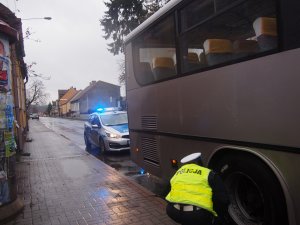 policjantka sprawdzająca koła autobusu
