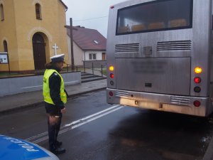 policjantka sprawdzając tylnie oświetlenie autobusu