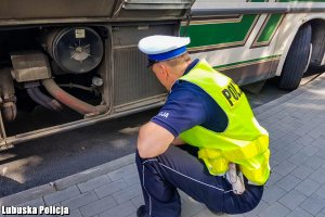 policjant kontrolujący autobus