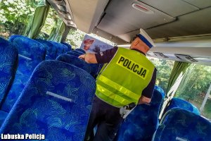 policjant kontrolujący autobus