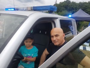 Policjant i dziecko przy radiowozie