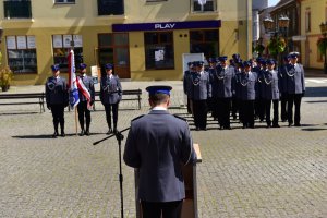 Przemówienie Komendanta Powiatowego Policji w Świebodzinie, w tle mianowani policjanci oraz poczet sztandarowy