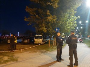 Dwóch policjantów w nocy na tle festynu