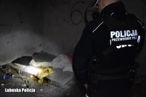 policjant świecący latarką na materac w pustostanie