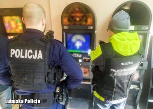policjant i funkcjonariusz Krajowej Administracji Skarbowej przy automacie do gier