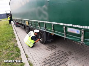 Policjant z Inspekcją Transportu Drogowego kontrolują ciężarówkę w mieście