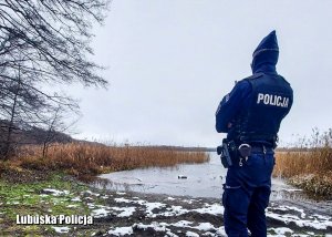 Policjant sprawdza czy nie ma żadnych osób na zamarzniętym jeziorze.