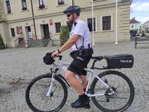 Policjant na rowerze przed ratuszem.