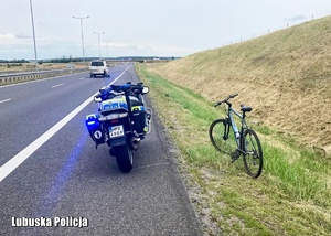 Policyjny motocykl oraz rower na trasie ekspresowej
